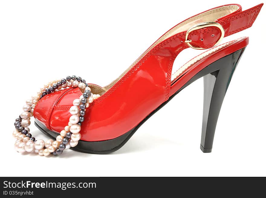 Woman red shoe with pearl necklace on a white background