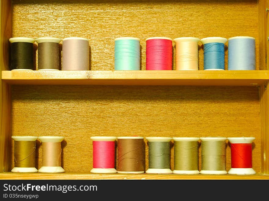 Colorful spool of thread on vintage wood shelf. Colorful spool of thread on vintage wood shelf