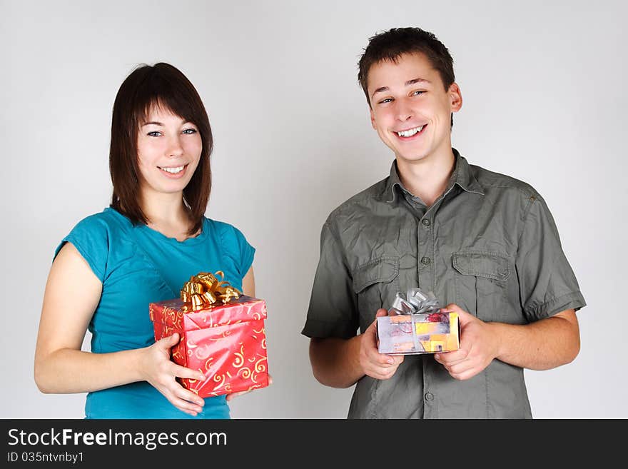 Young brunette girl and man holding gifts and smiling