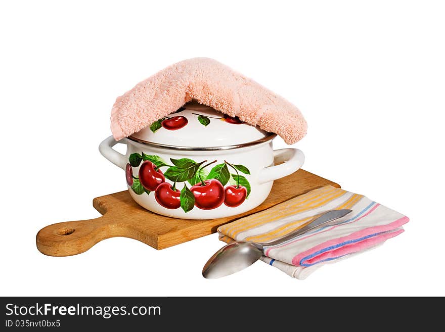 A metal pan and kitchen utensils on a cutting board.