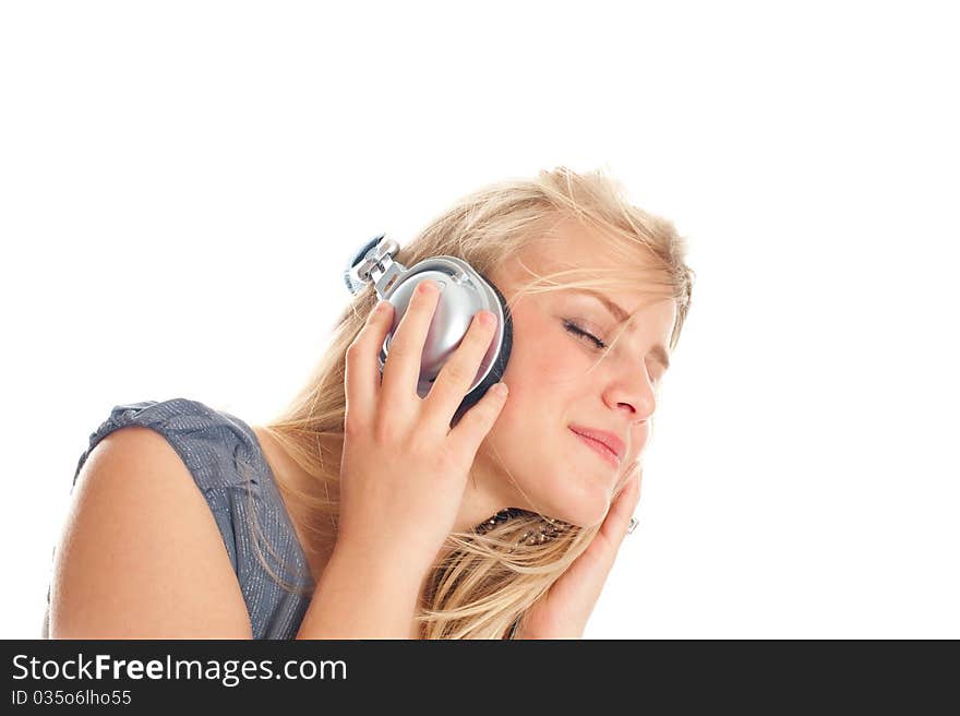 Young lady listening to music on headphones against white background