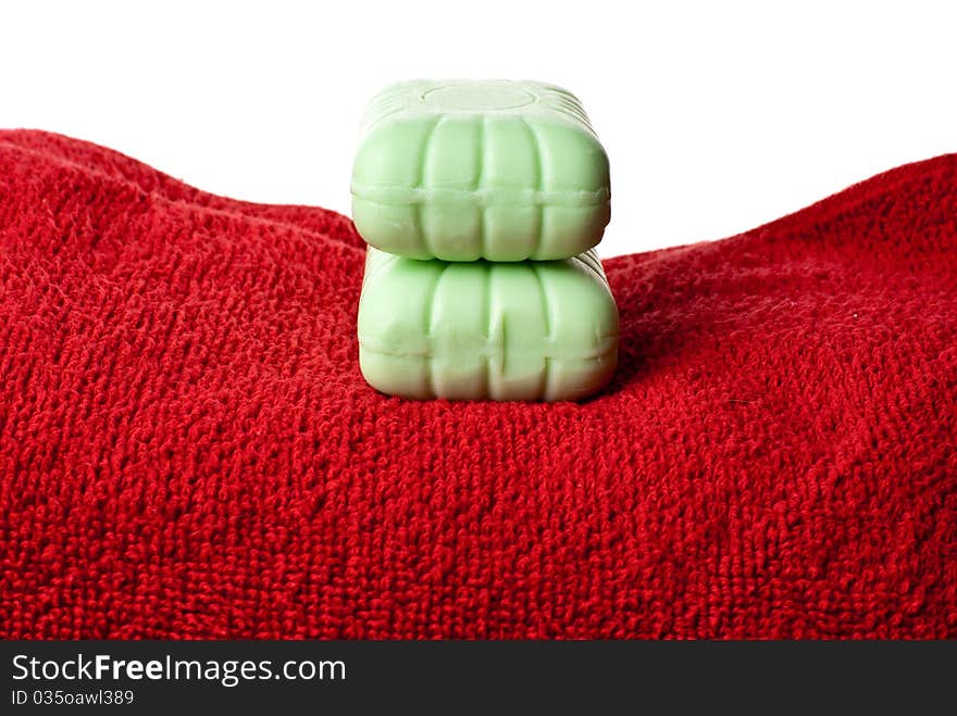 Two pieces of soap lying on red towel. Two pieces of soap lying on red towel.