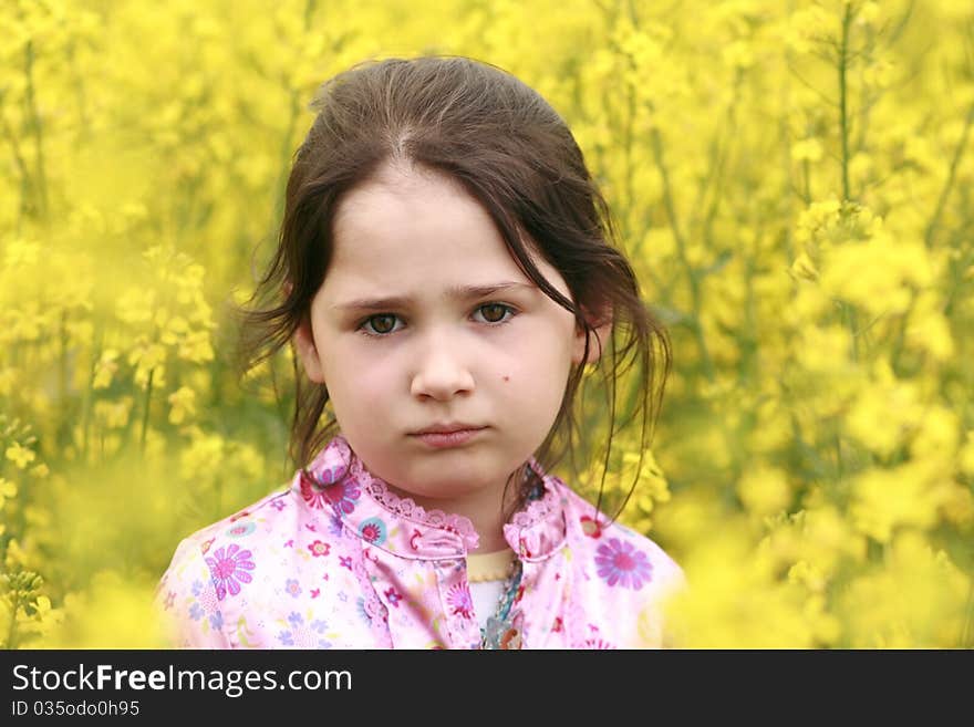 Sad girl portrait on yellow flowers background