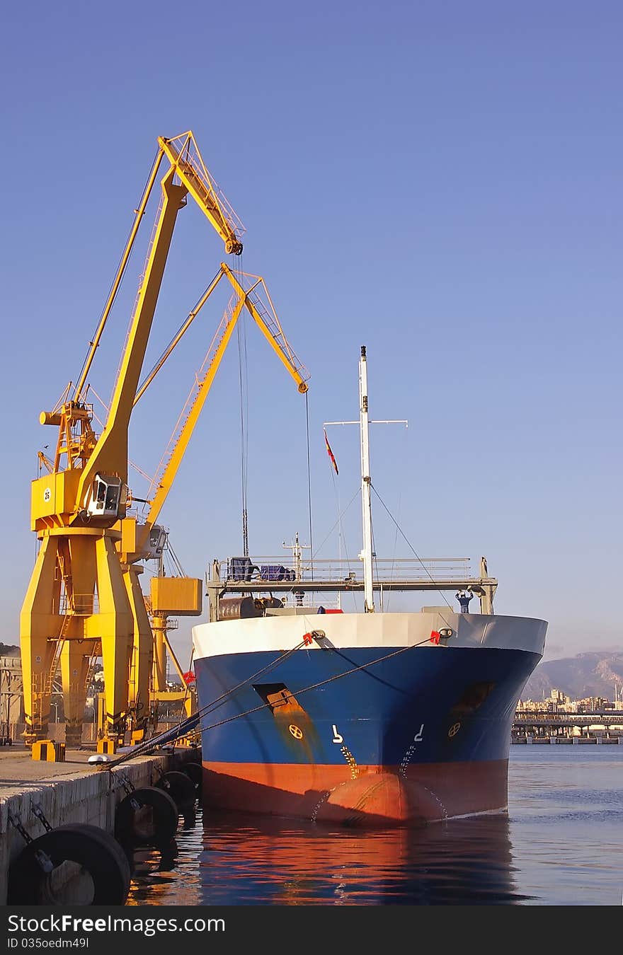 Unloading a docked ship with large cranes. Unloading a docked ship with large cranes