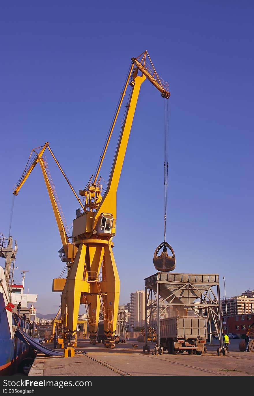 Giant cranes unloading a cargo ship in the Mediterranean Sea. Giant cranes unloading a cargo ship in the Mediterranean Sea