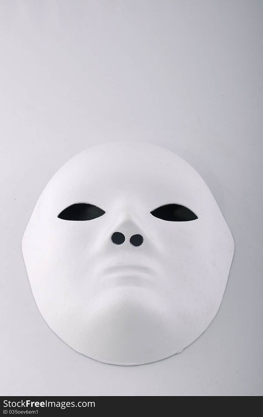 White mask with black eyes on a white background