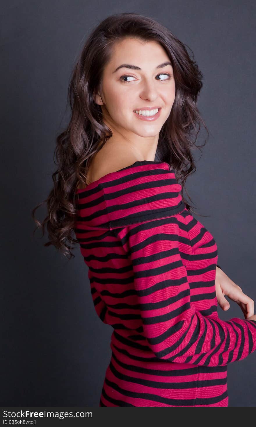 A cute, fun portrait of a beautiful young woman wearing a red and black sweater dress and patterned tights and smiling happily at the viewer. A cute, fun portrait of a beautiful young woman wearing a red and black sweater dress and patterned tights and smiling happily at the viewer.