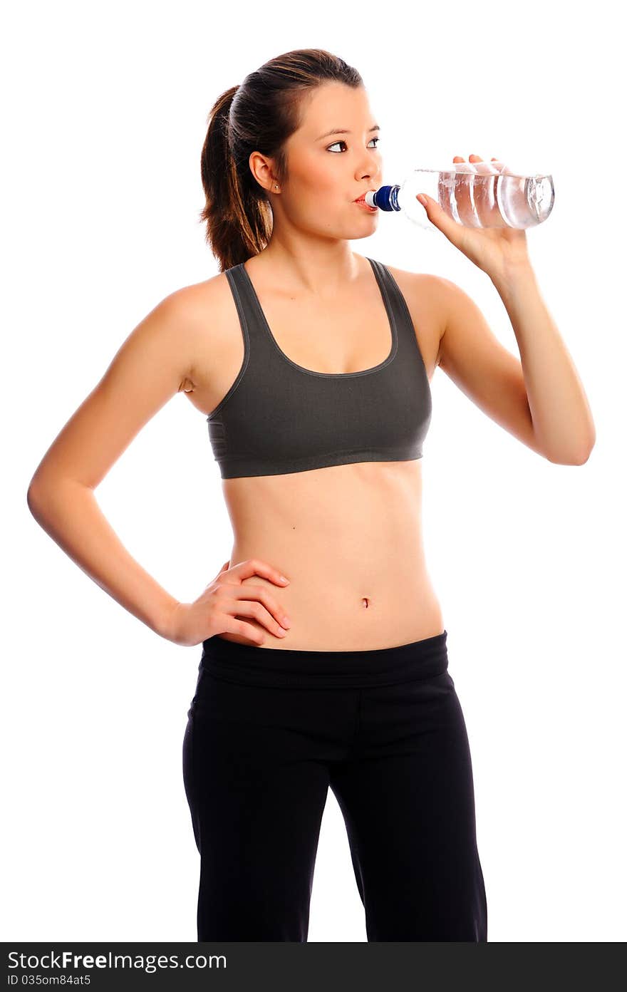 Attractive young woman resting between exercises with water bottle. Attractive young woman resting between exercises with water bottle