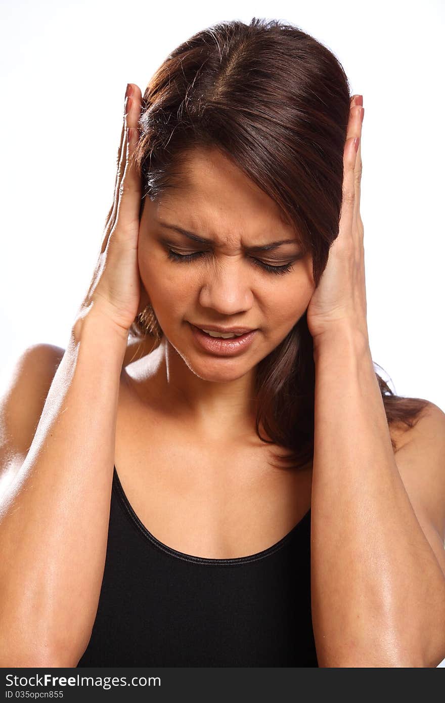 Headshot of beautiful young woman, hands over ears and face showing anguish. Woman indicating she is unhappy, hurt and in a state of disbelief. Headshot of beautiful young woman, hands over ears and face showing anguish. Woman indicating she is unhappy, hurt and in a state of disbelief.