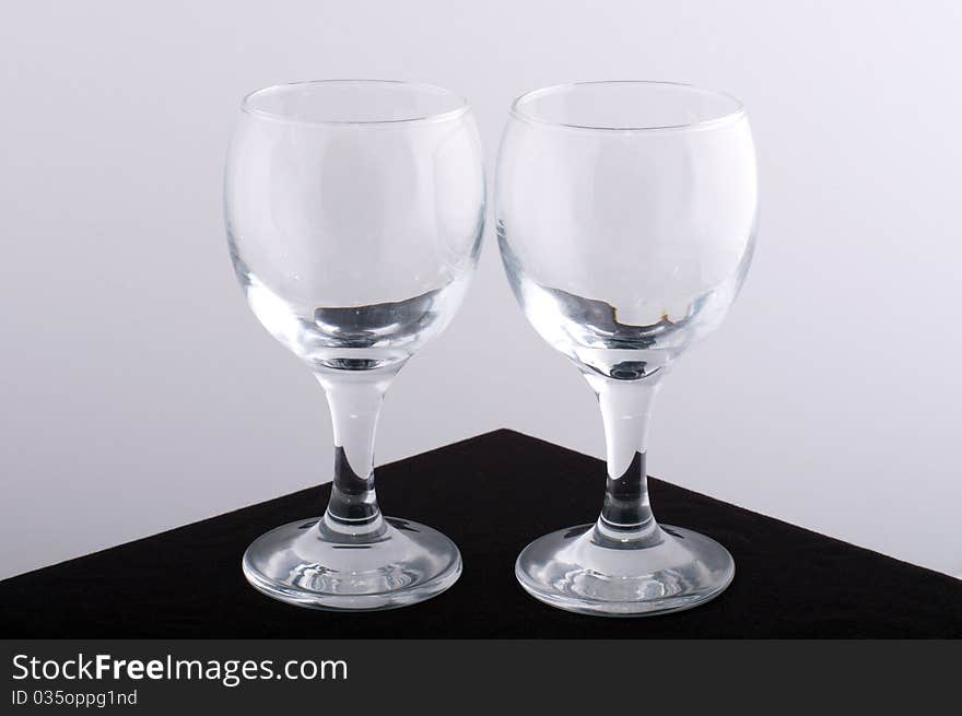 Glass wine glasses on a brown table with a white background. Glass wine glasses on a brown table with a white background