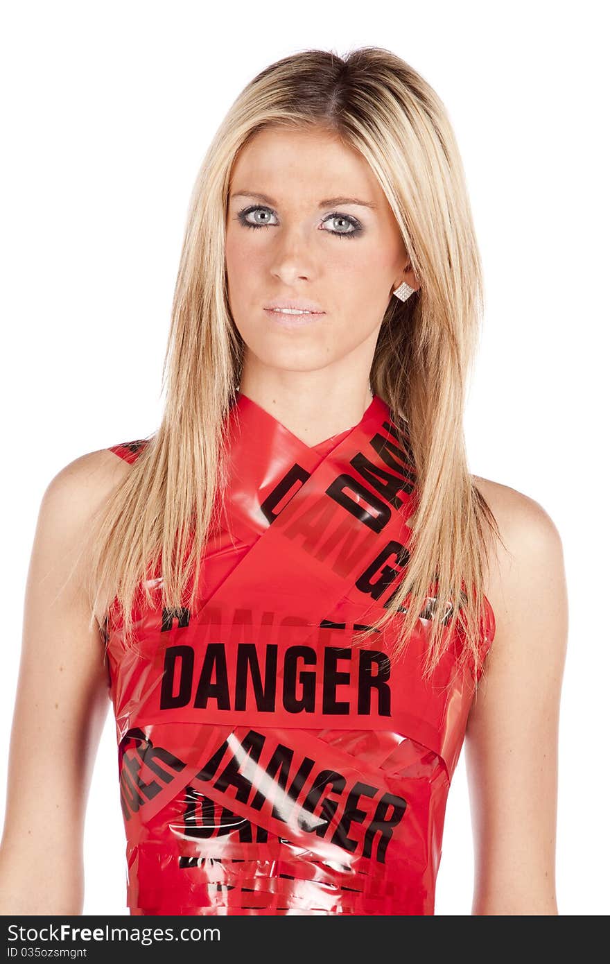 A woman is wrapped in danger tape like a dress and is serious. A woman is wrapped in danger tape like a dress and is serious.