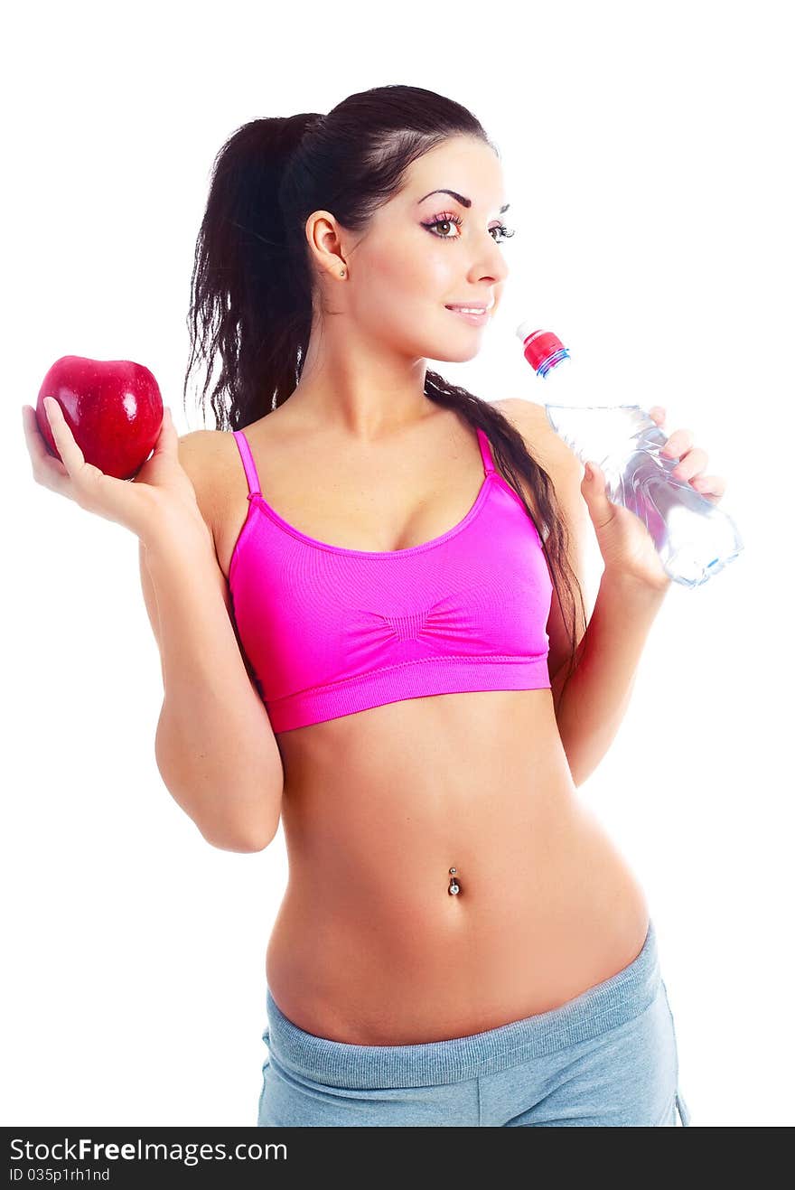 Beautiful young sporty woman drinking mineral water and holding an apple. Beautiful young sporty woman drinking mineral water and holding an apple