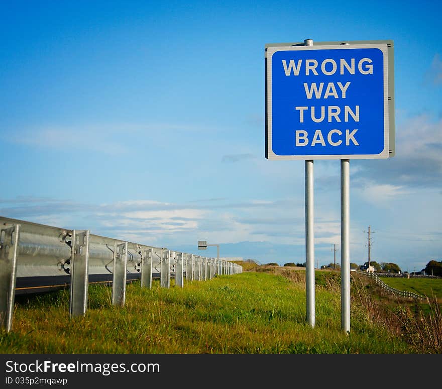 Road  sign ' Wrong Way' and blue sky with clouds