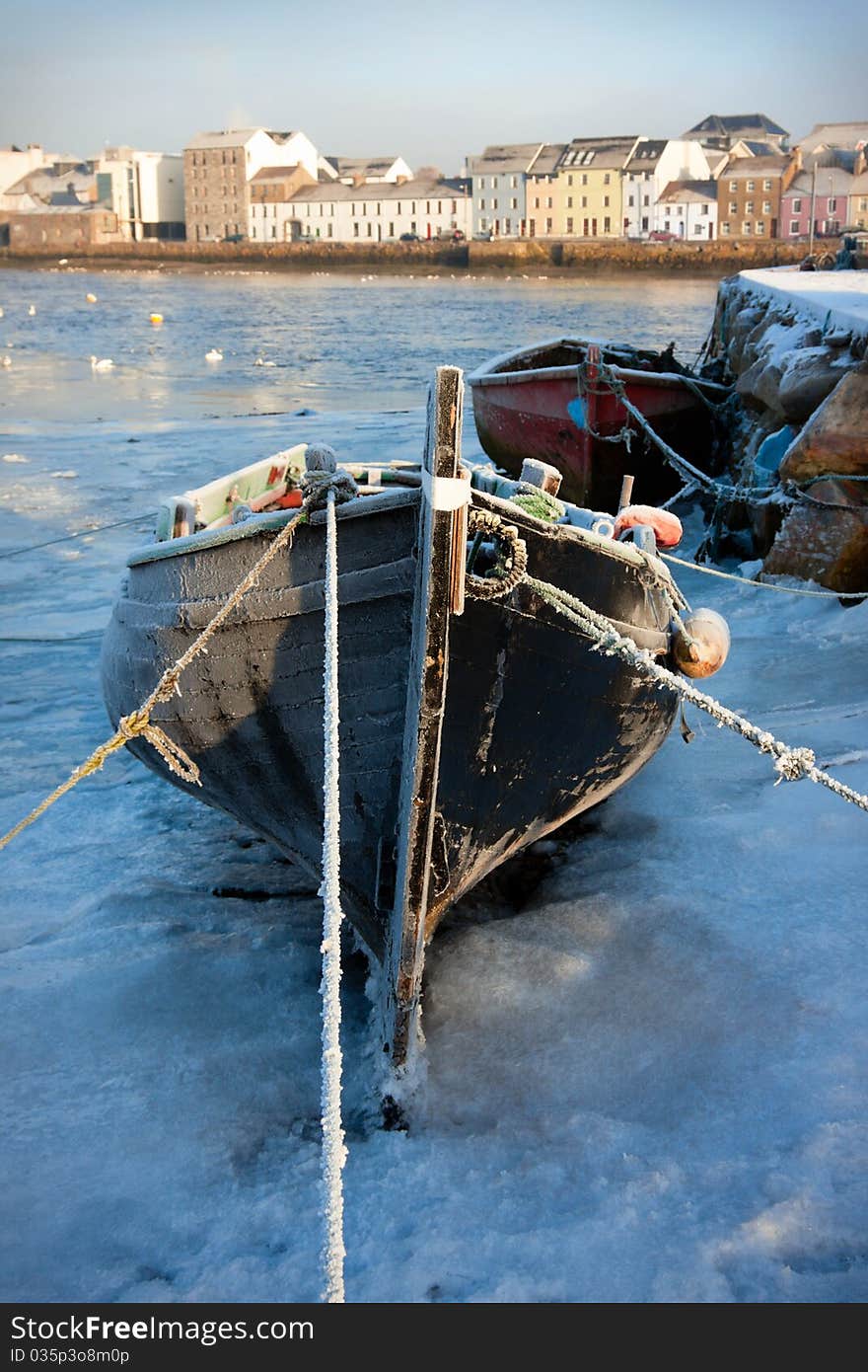 Boats in ice on the bank of river