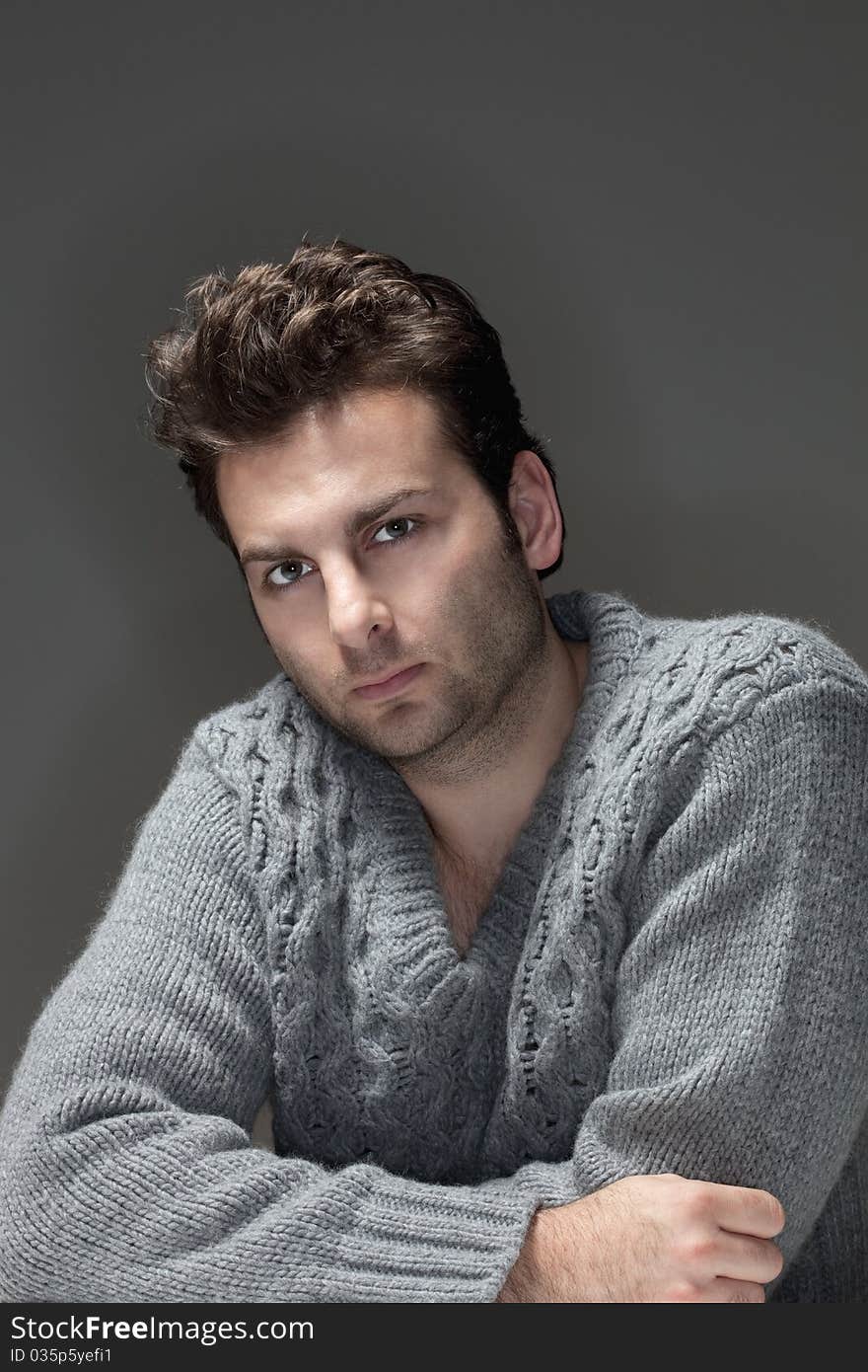 Portrait of a man in a sweater looking at camera - isolated on gray