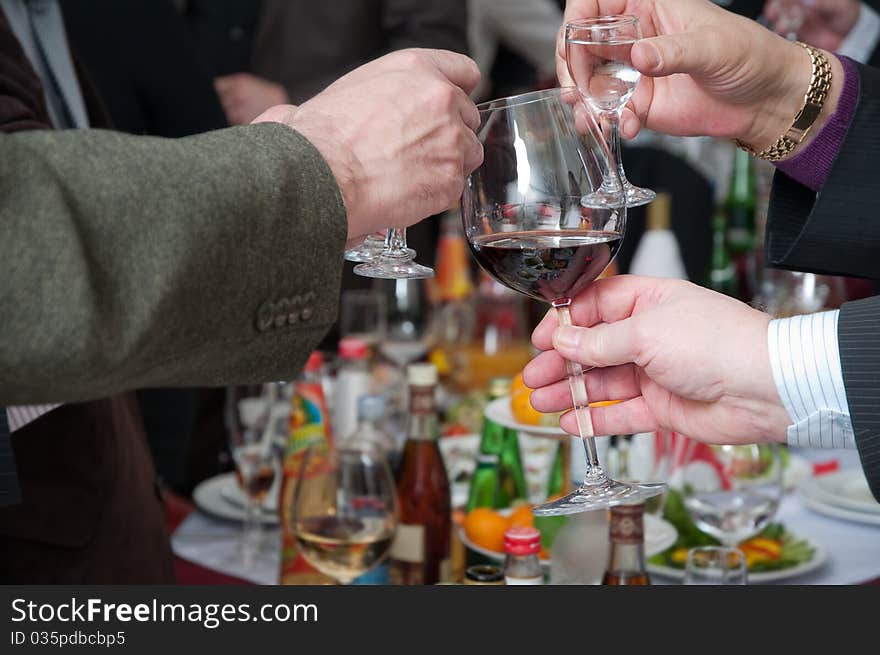 Hands of people hold wine glasses with alcoholic drinks. Hands of people hold wine glasses with alcoholic drinks.