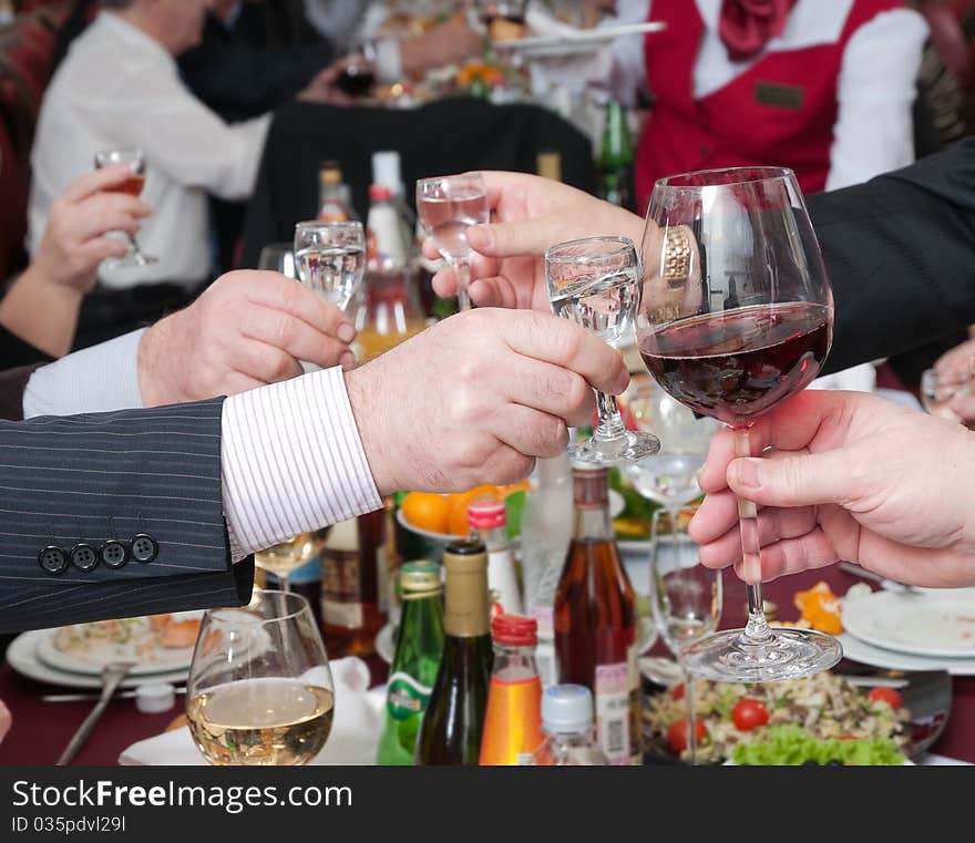 Hands of people hold wine glasses with alcoholic drinks. Hands of people hold wine glasses with alcoholic drinks.