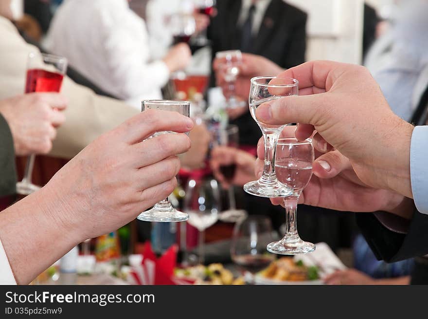 Hands of people hold wine glasses with alcoholic drinks. Hands of people hold wine glasses with alcoholic drinks.