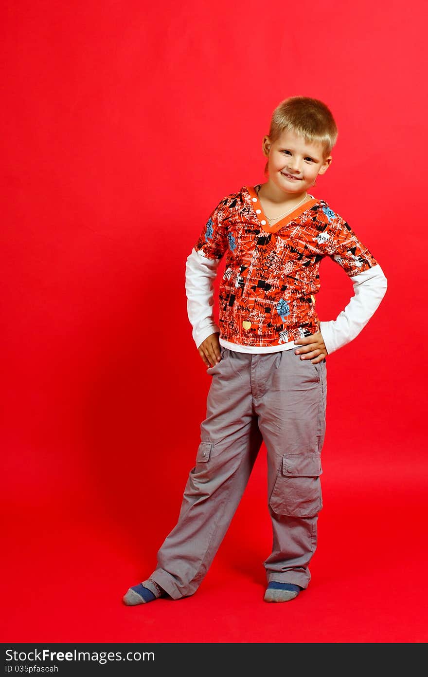 Merry little boy on a red background