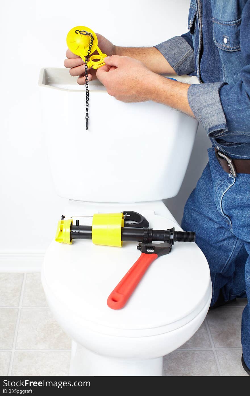 Plumber repairing a flush toilet. Plumber repairing a flush toilet