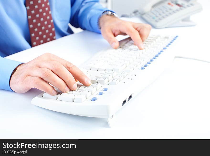 Male hands typing on a white keyboard