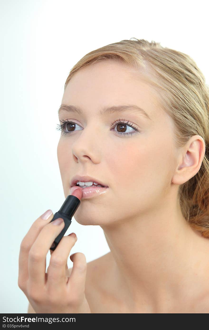 Portrait of a young woman applying make-up. Portrait of a young woman applying make-up