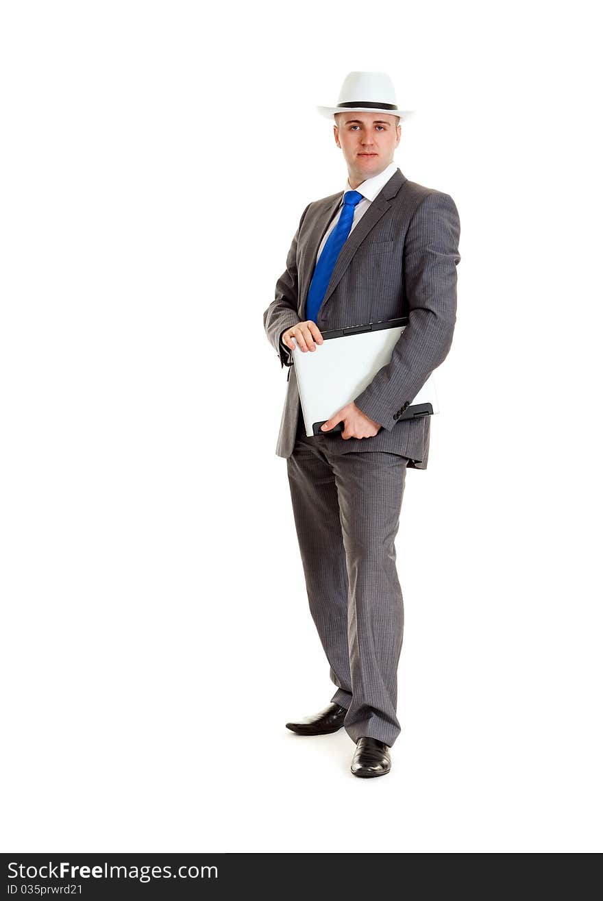 Young businessman in a suit and a hat with a laptop