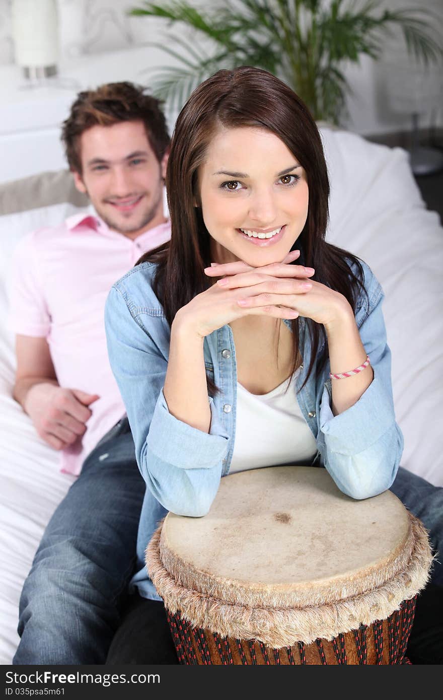 Young man and young woman smiling with a djembe. Young man and young woman smiling with a djembe