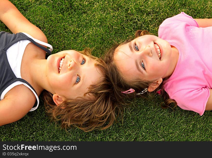 Two smiling girl lying on the grass