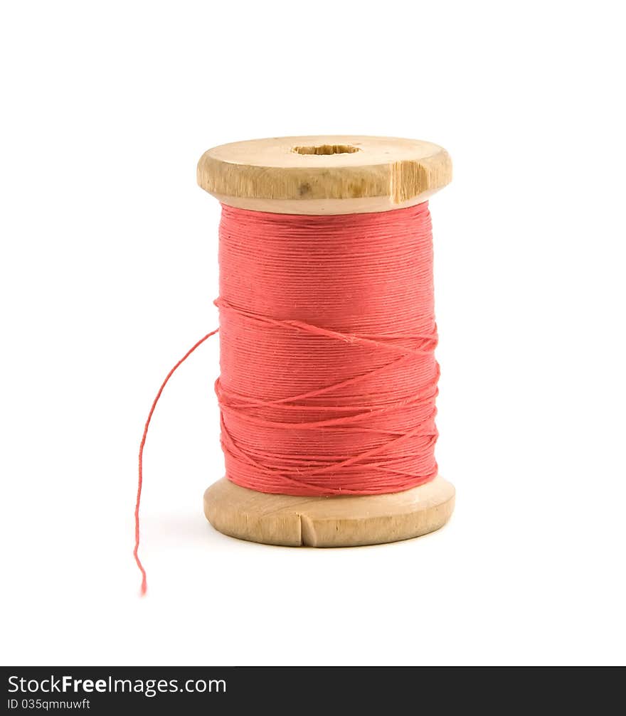 Bobbin with red thread over white. Bobbin with red thread over white