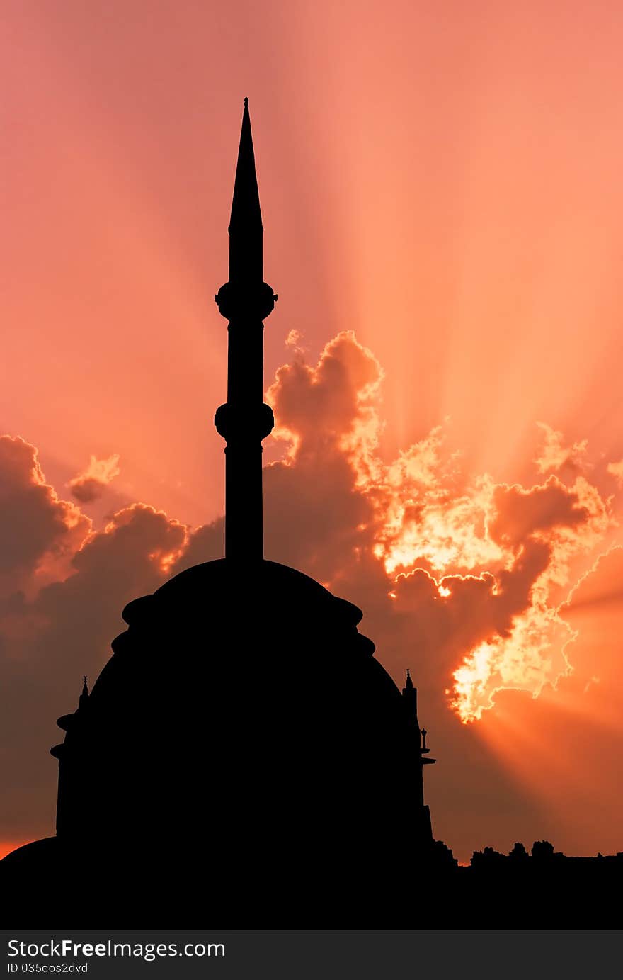 Small  modern Turkish mosque outlined by sunset showing dome and minaret. Small  modern Turkish mosque outlined by sunset showing dome and minaret.