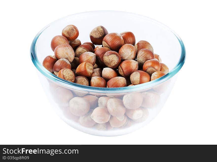 Glass dish with nuts isolated on a white background