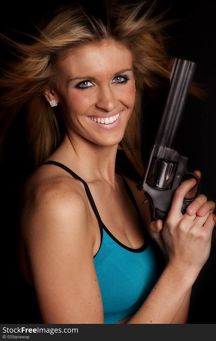 A woman is holding a gun and smiling. A woman is holding a gun and smiling.