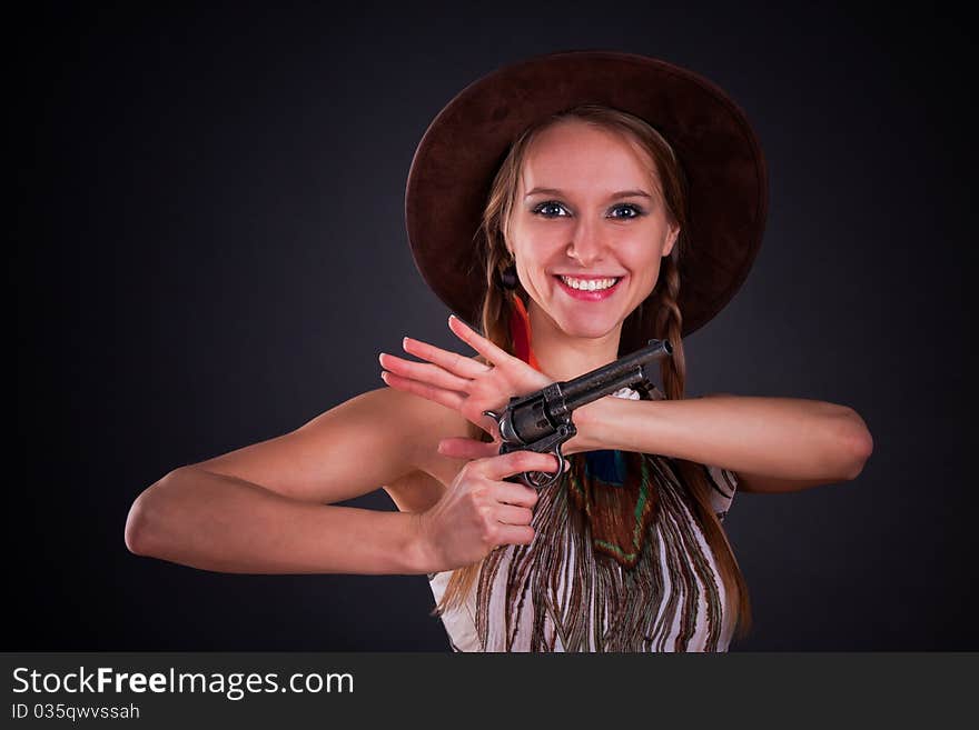 The American Indian girl in a cowboy's hat holds a pistol