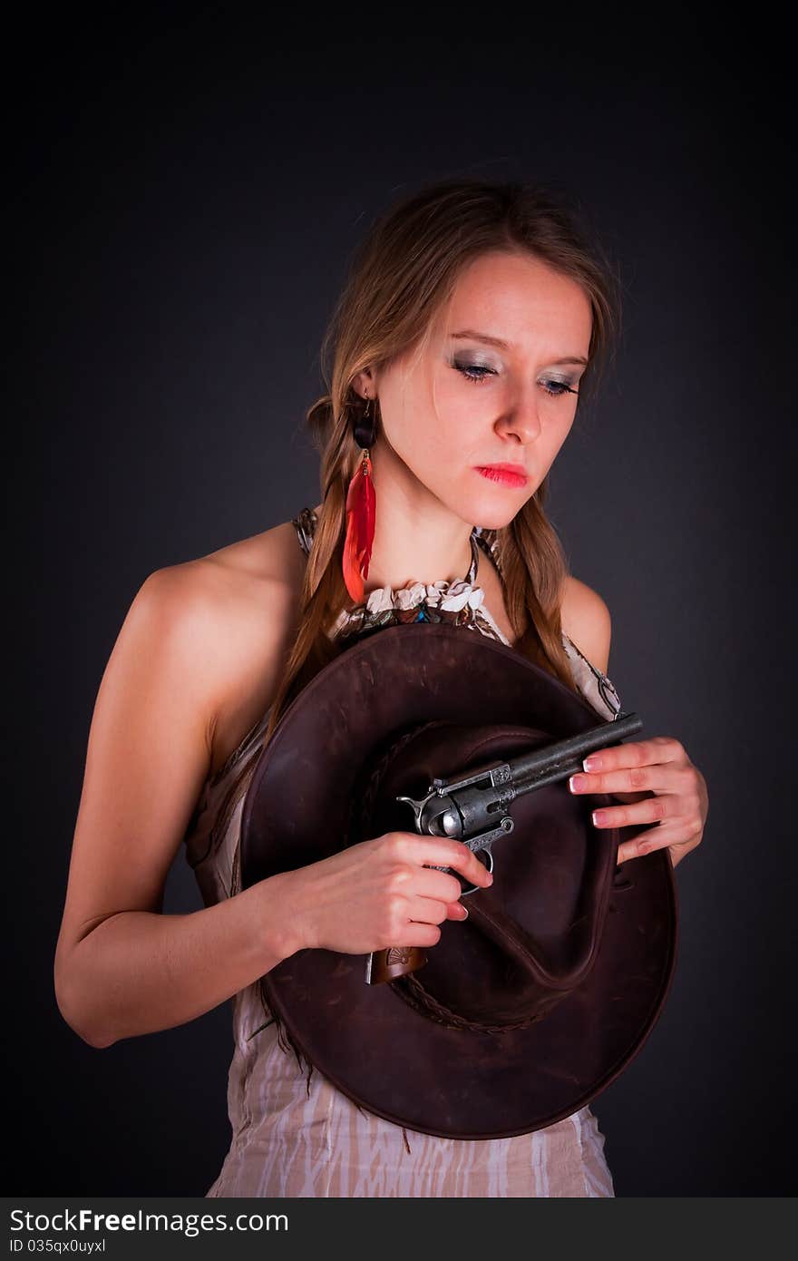 The American Indian girl with a cowboy's hat holds a pistol