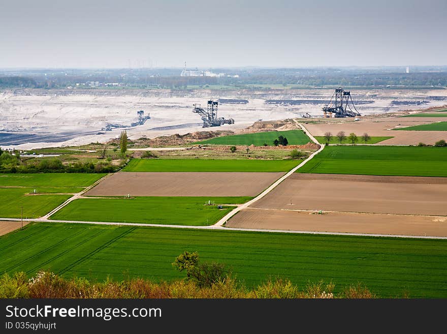 A coal mine in background, destroyed fields in foreground. A coal mine in background, destroyed fields in foreground