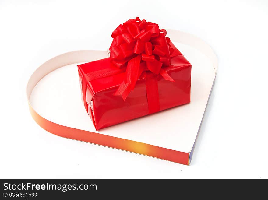 Red gift inside a heart box isolated in white