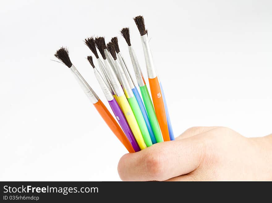 Different sizes watercolor paint  brushes held in a persons hand. Different sizes watercolor paint  brushes held in a persons hand