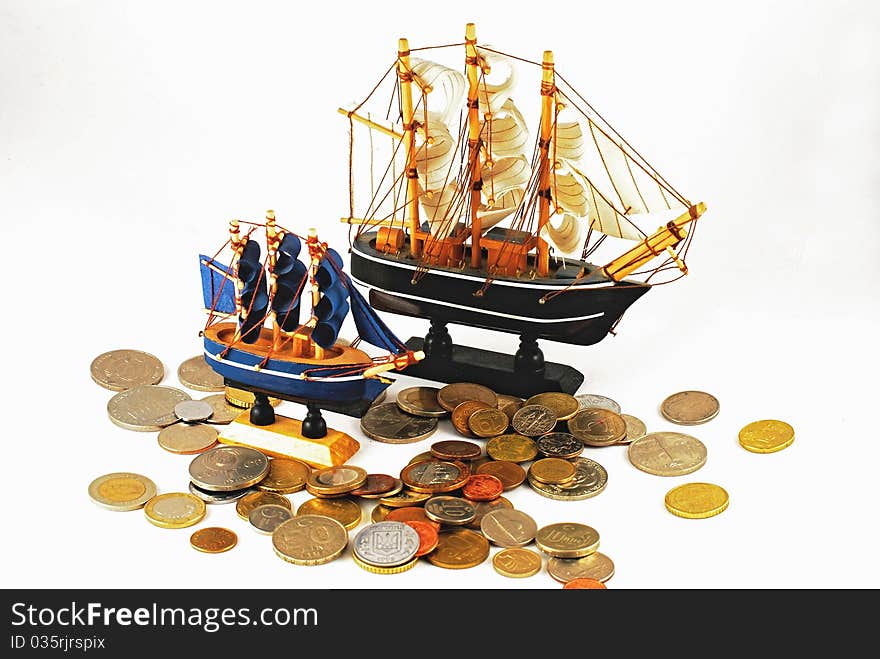 Model ships and coins on white background