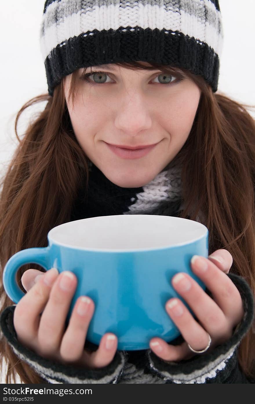 Beautiful girl with a smile, holding a large blue mug. Beautiful girl with a smile, holding a large blue mug