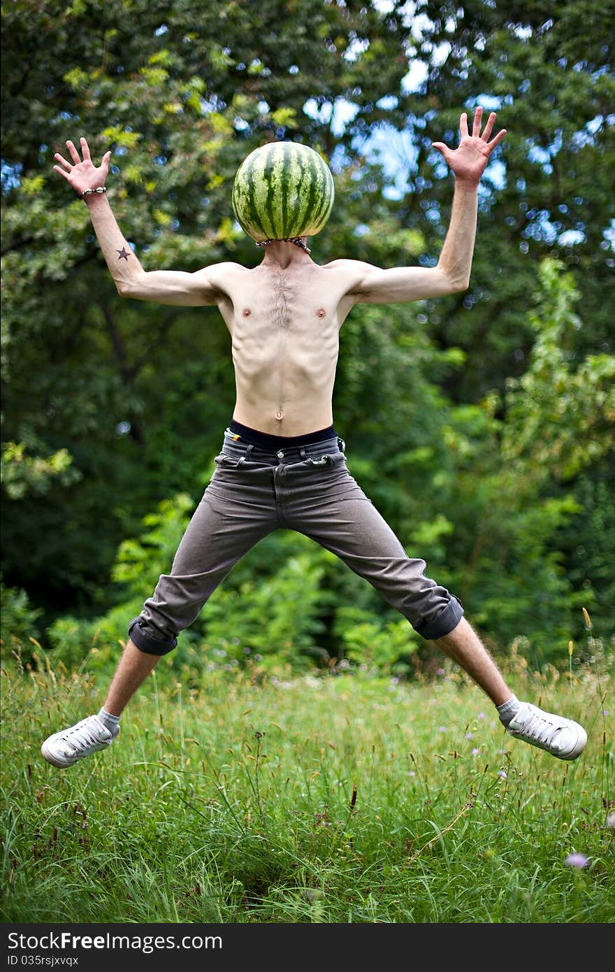 Humorous photo of a jumping boy with a watermelon instead of head. Humorous photo of a jumping boy with a watermelon instead of head