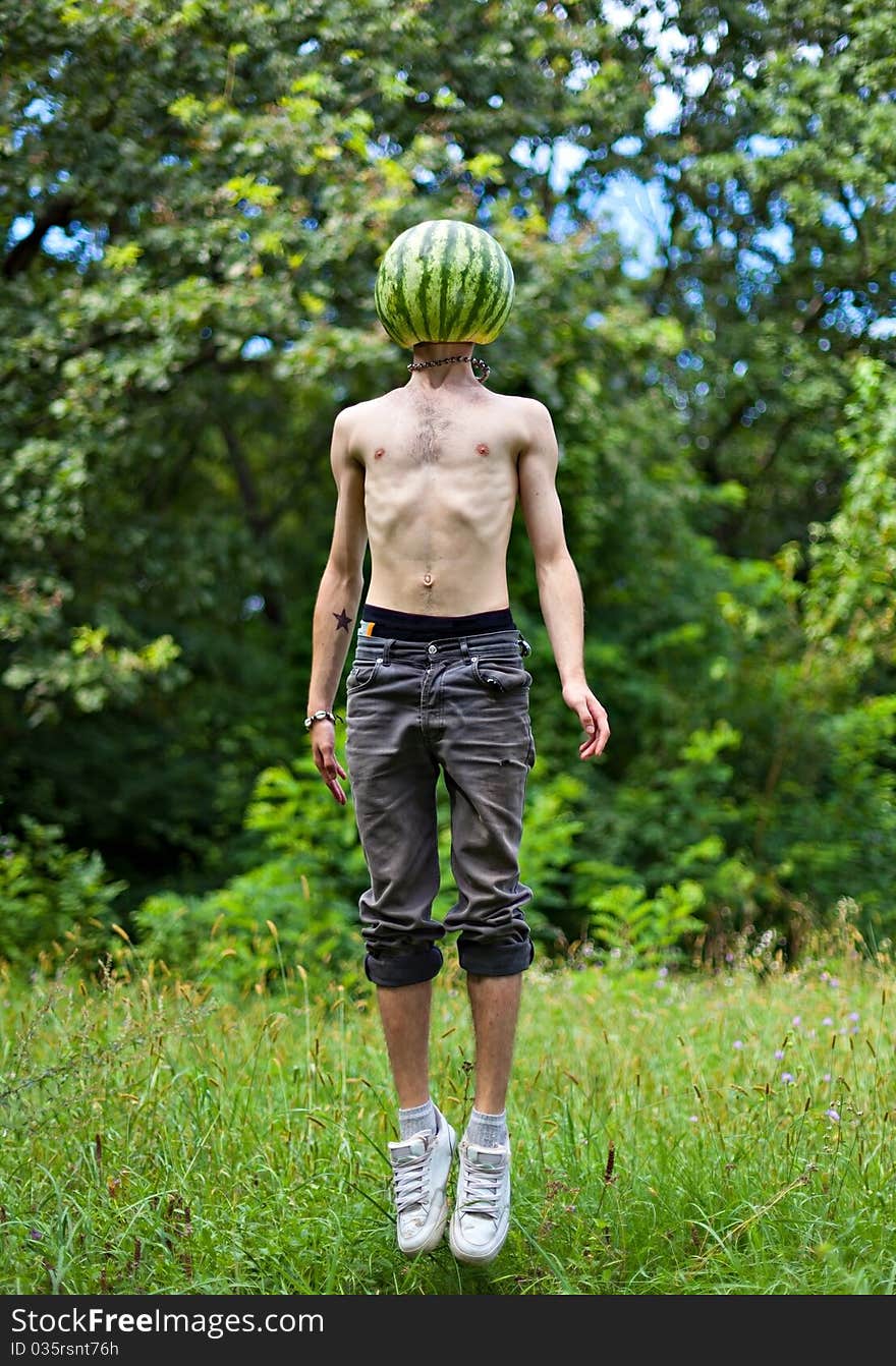 Humorous photo of a jumping boy with a watermelon instead of head. Humorous photo of a jumping boy with a watermelon instead of head