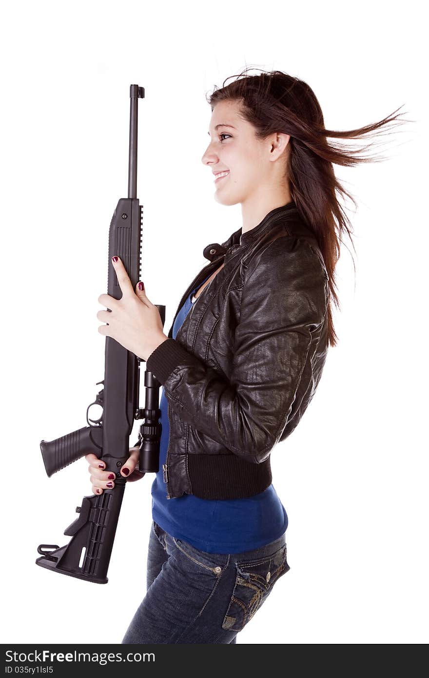 The side view of a woman with a shot gun in her hands with a smile on her face. The side view of a woman with a shot gun in her hands with a smile on her face.