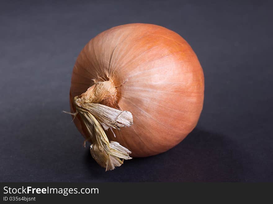 Image of an unpeeled onion on a black background