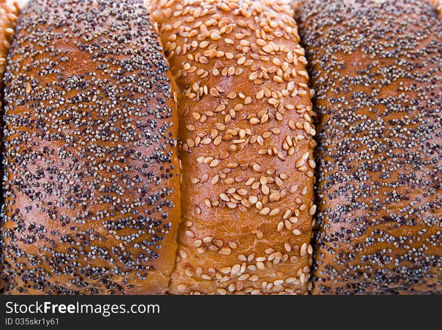 Background of fresh bread, sprinkled with sesame seeds. Background of fresh bread, sprinkled with sesame seeds