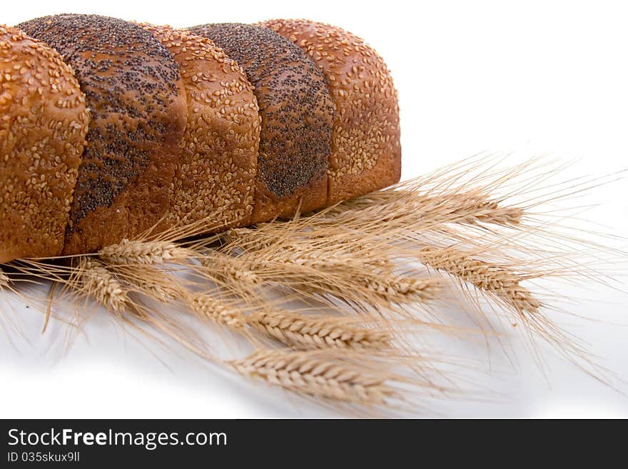 Fresh bread with ears of wheat on a white background