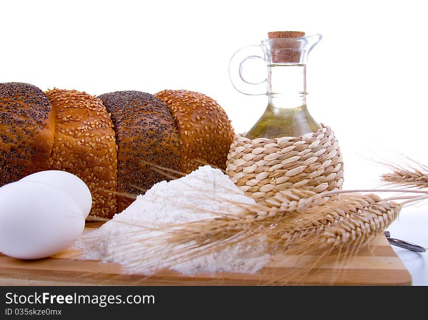 Fresh bread,  eggs,  flour  and  oil  on  wood  board