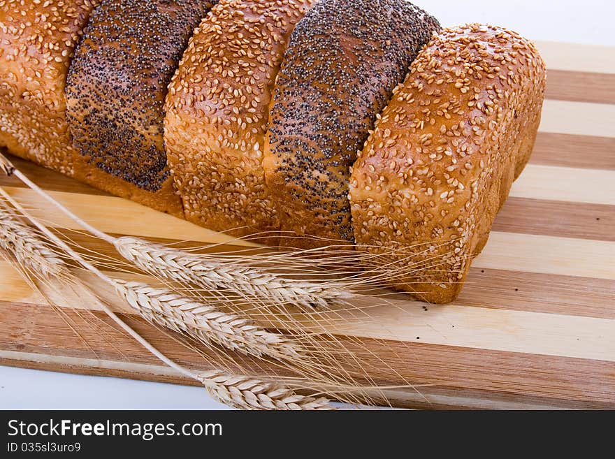 Fresh bread with ears of wheat  on a white background