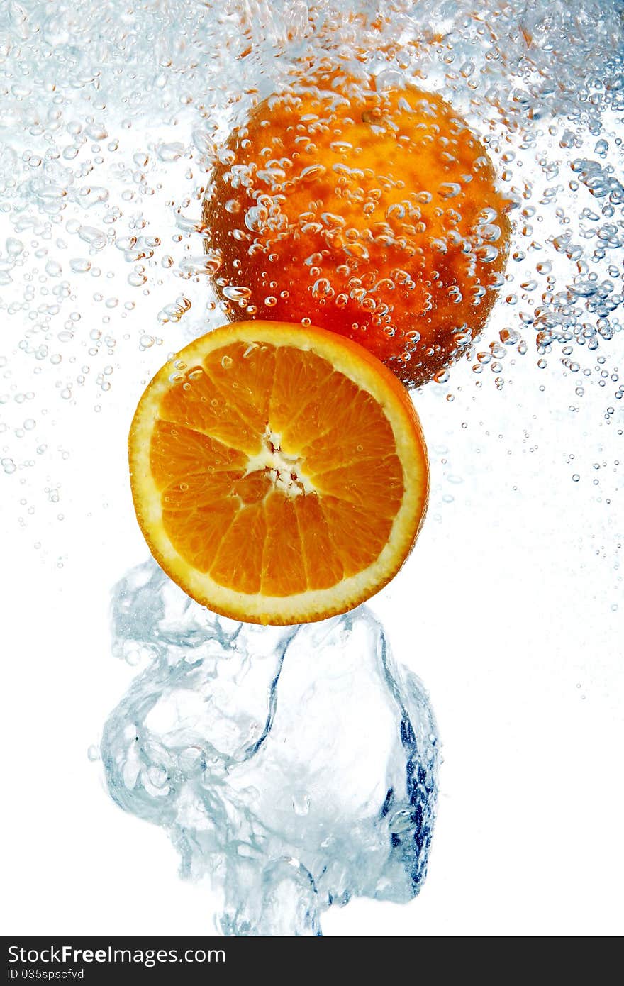 Fresh oranges dropped into water