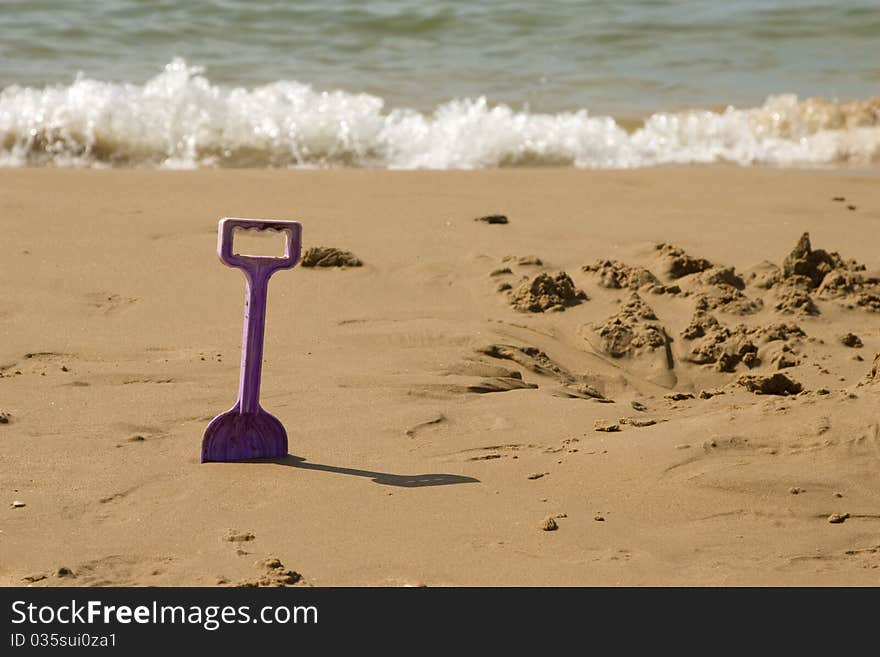 Toy spade on the sunny beach. Toy spade on the sunny beach